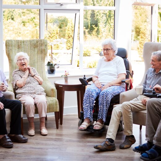Elderly Residents Of An Extra Care Sat Together Talking And Laughing