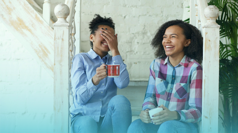 Equality And Diversity In The Workplace: Why It Matters In Health And Social Care - New Blog | April 26 Equality And Diversity, Two Black Women Laughing And Discussing Over A Cup Of Coffee Or Tea