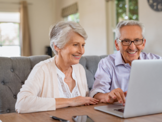 elderly care options - couple sitting at a laptop researching care options